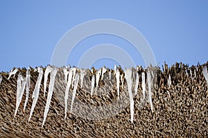 Icicles retro straw roof background blue sky