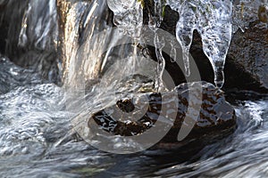 Icicles on rocks in a fast stream