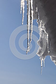 Icicles on the roof and blue sky, winter nature