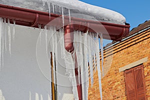 Icicles on the downpipe,icicles on the roof of the house on plastic drainage pipes, drainage pipes in winter