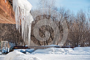 Icicles on the roof. Melt the snow on the roof of the house. Caution icicles. Ice hanging from the roof of the house