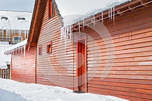 Icicles and snow on an old wooden cottage