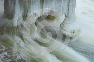 icicles under a jetty in fast streaming water