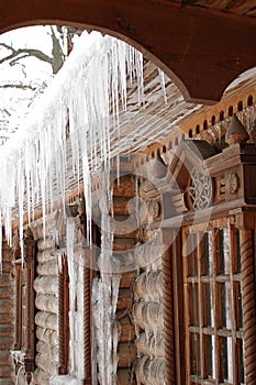 Icicles in winter. Icicles on a wooden hut. Wooden house in ice. Ice covers the log walls and icicles hang from the roof