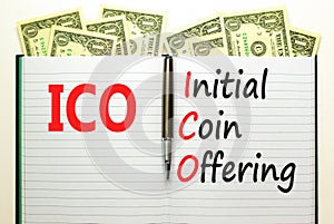 ICO initial coin offering symbol. Concept words ICO initial coin offering on beautiful white note. Beautiful dollar bills