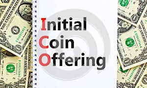 ICO initial coin offering symbol. Concept words ICO initial coin offering on beautiful white note. Beautiful dollar bills