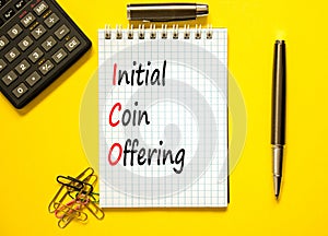 ICO initial coin offering symbol. Concept words ICO initial coin offering on beautiful white note. Beautiful yellow background.