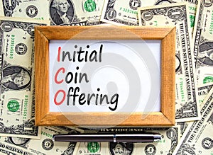ICO initial coin offering symbol. Concept words ICO initial coin offering on beautiful wooden frame. Beautiful dollar bills