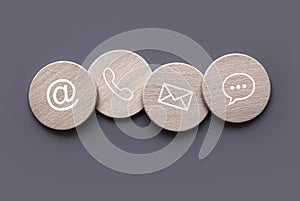 Icon of communication type on wooden circle. Contact us or Customer support hotline people connect
