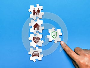Icon of healthcare, house, family, and car on jisaw puzzle. Concept of insurance coverage.