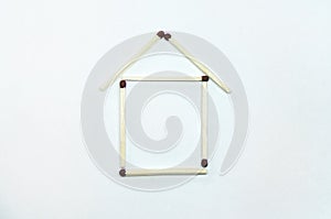 Icon of the house. The house is laid out of matches on a white background. The concept of building and buying a house.