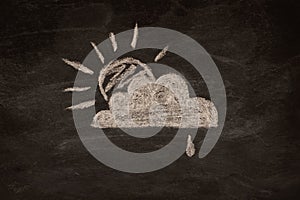 Icon for weather forecast, partly cloudy and light rain drawn with chalk on blackboard.