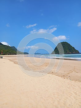 Iconic Banyuwangi (indonesia) Beach called Pantai Pulau Merah with blue sky and a uninhabited island. taken at May, 2023