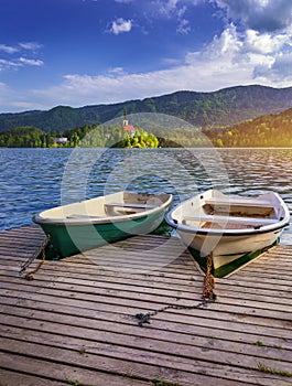 Iconic Bled scenery. Traditional wooden boats Pletna at lake Bled, Slovenia, Europe. Wooden boats with Pilgrimage Church of the