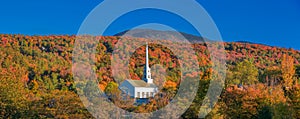 Iconic church in Stowe Vermont middle of fall foliage