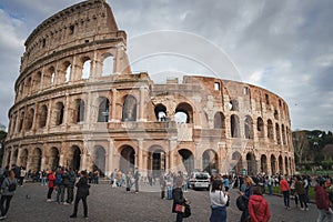 Iconic Colosseum in Rome with tourists and cloudy sky in ancient splendor