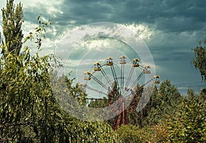 Iconic ferris wheel in town of pripyat, abandoned chernobyl exclusion zone. Seen from the distance, surrounded by trees in the