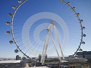 Iconic large Ferris wheel stands out in urban skyline, clear day