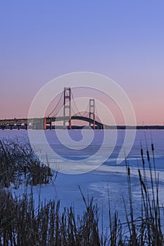 Iconic Mackinac bridge in frozen Lake Michigan under twilight