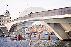 Iconic Nyhavn with its colorful houses and old boats seen under the walking bridge Inderhavnsbroen.