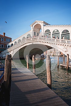 Iconic Rialto Bridge spanning the Grand Canal in Venice, Italy amidst bustling cityscape.