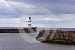 Iconic striped Seaham lighthouse on pier with sea walls