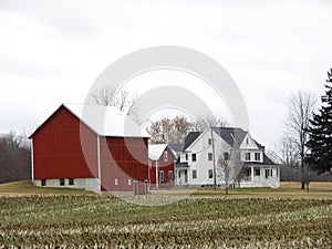 Iconic white farmhouse with red barns in NYS FingerLakes countryside