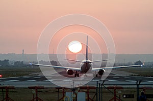 Iconical image of Airplane landing at an airport at sunset photo