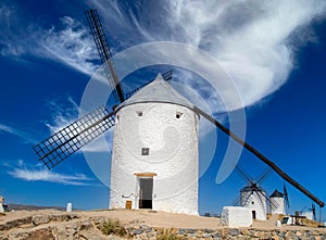 iconical view of windmills with castle in the background in europe photo