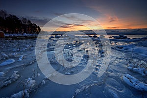 Icy beach in sunrise.