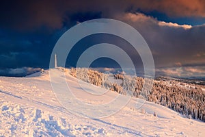 Icy cellular base station antenna covered with snow. Cell site tower on moutain hill. Telephone network transceivers and