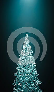 Icy christmas tree on dark background with volumetric light. Vertical xmas backdrop with copy space