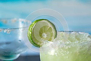 Icy frozen margarita drinks with slices of lime