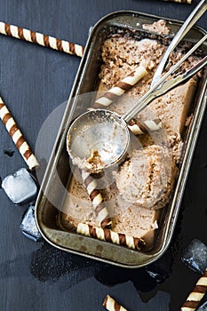 Icy homemade chocolate ice cream or sorbet with rustic scoop and