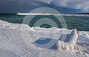 Icy Park Bench With Pier In Background