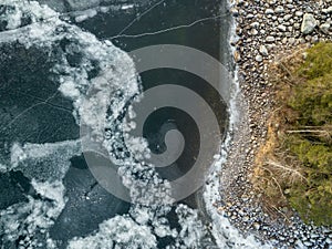 Icy patterns on ice cover of a frozen lake at shore