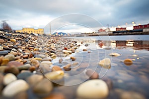 icy pebbles on a shore with cloud reflections