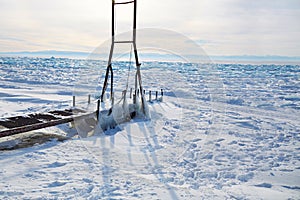 Icy pier, a device for launching a boat into the lake. Frozen Lake Baikal, hummocks