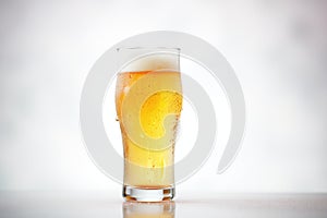 icy pilsner glass with water droplets, plain background