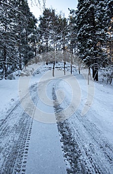 Icy slippery dangerous road in winter in the forest. Snowy mountains snowstorm.