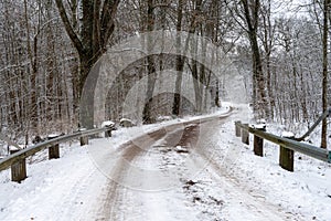 An icy and snowy winter road going through a forest. Picture from Eslov, Sweden