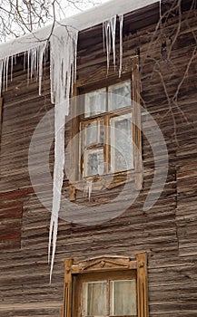 Icy transparent icicles hang on the edge of the roof.