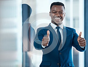 Id love to work with a winner like you. a young businessman showing thumbs up in a modern office.