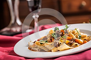 Idalian pasta pappardelle with beef ragout on white plate and re