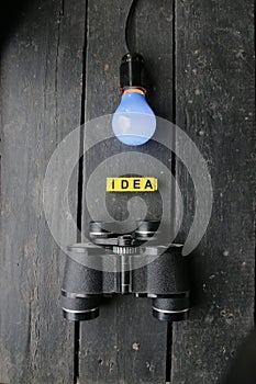 Idea concept. Blue Light lamp and vintage binoculars