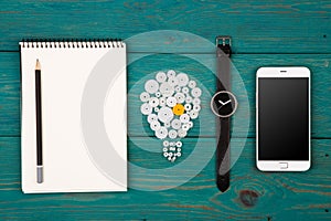 idea concept - bulb sign, notepad, watch and phone on the desk