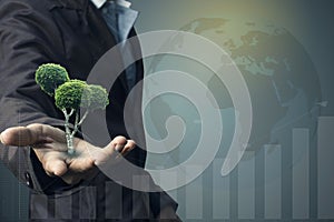 Idea Concept green planet. Businessman holding gift box and green trees growing