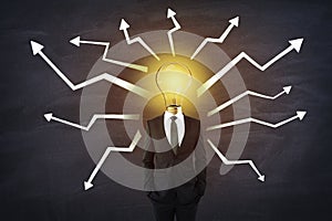 Idea concept with man in black suit and glowing light bulb instead of head with white arrows directed in different directions on