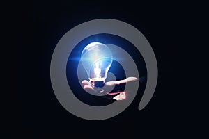 Idea concept. Man with glowing light bulb in darkness