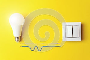 Idea, innovation, creativity concept with glowing light bulb and switch with wires phase, zero on Yellow Background. Power energy